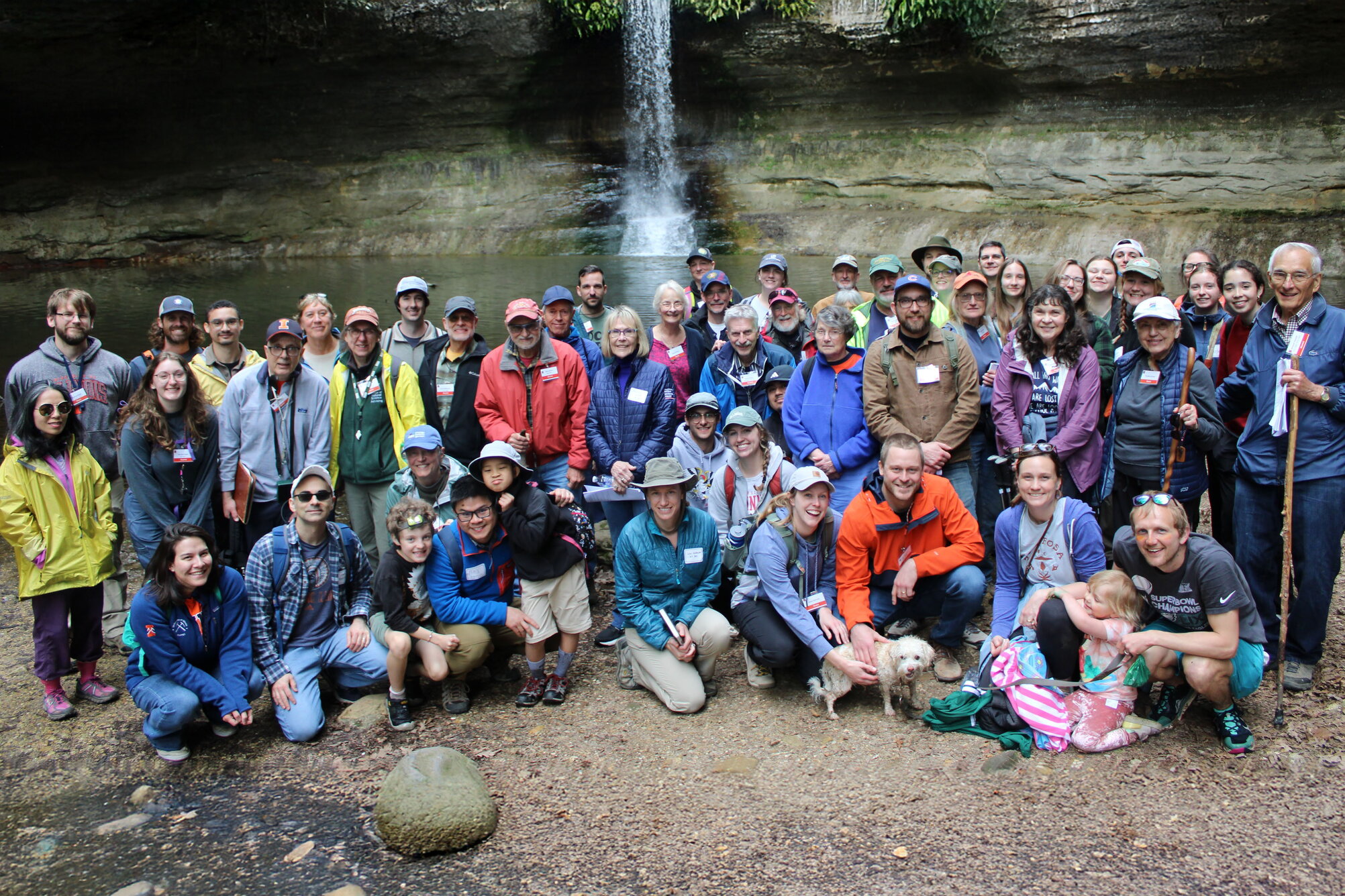 A group of people and a dog posing for a picture.