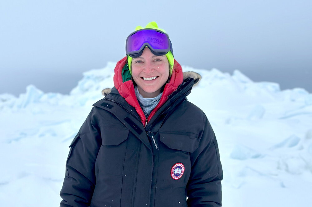 A person standing on ice in winter gear.