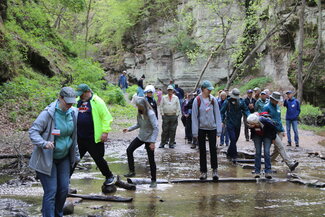 A group of people crossing a creek