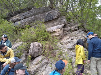 A group of people staring a rocky outcropping