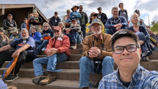 A selfie of a group of people sitting on stairs