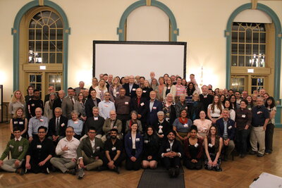 A group of people posing for a group photo in a ballroom.