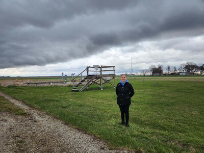 Allison Wallin standing in front of a weather station on an overcast day.