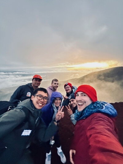 A group on a mountaintop above the clouds.