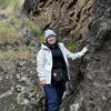 A person standing next to a rocky cliff.