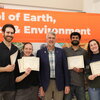 People posing for a photo with award certificates.