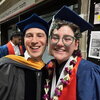Two people in graduation caps and gowns posing for a picture.