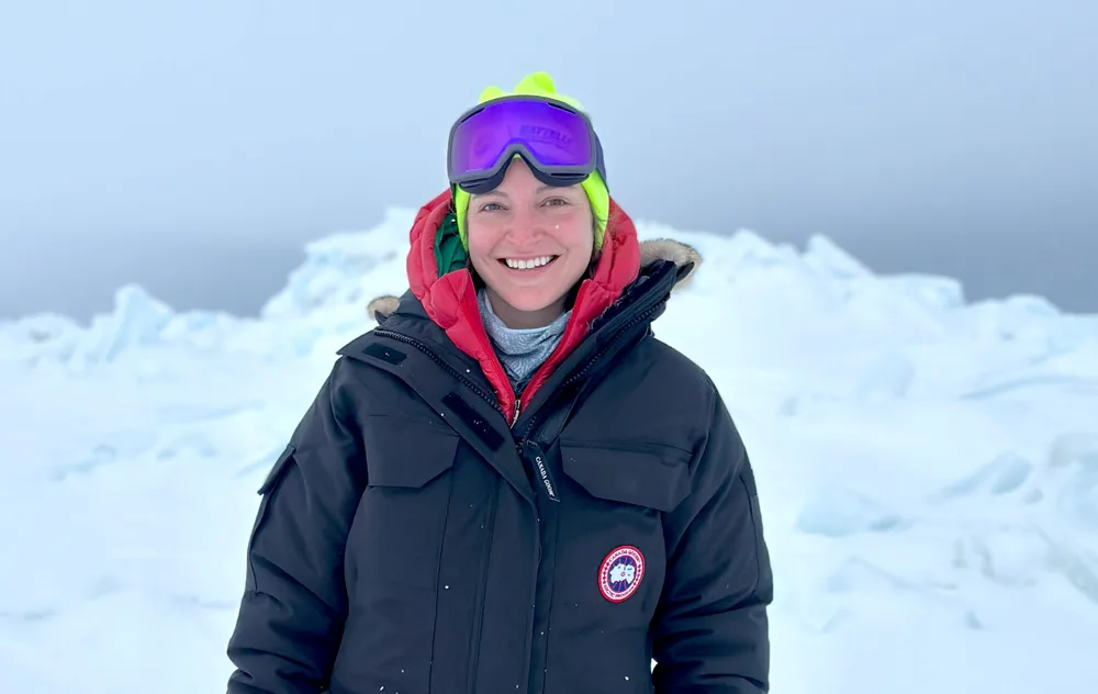A person standing on ice in winter gear.